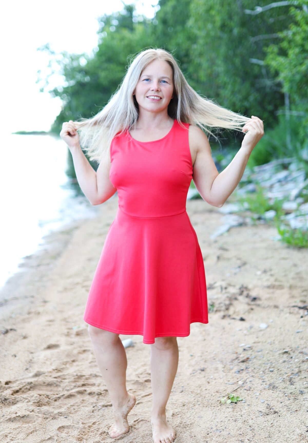 Blondine zieht sich am Strand aus