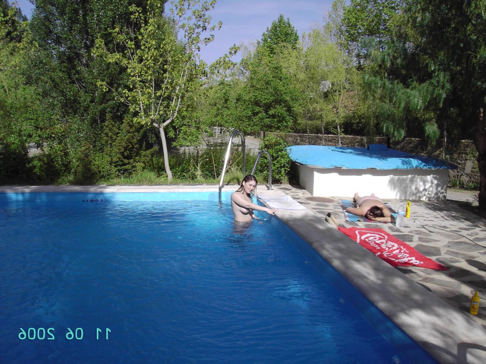 Chica en topless en la piscina del camping