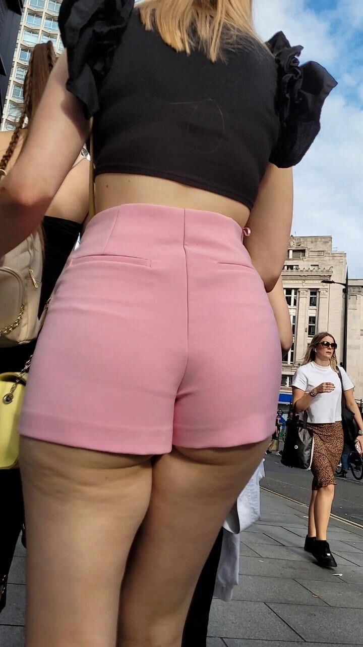 Hermosa adolescente en pantalones cortos de color rosa con culo caliente