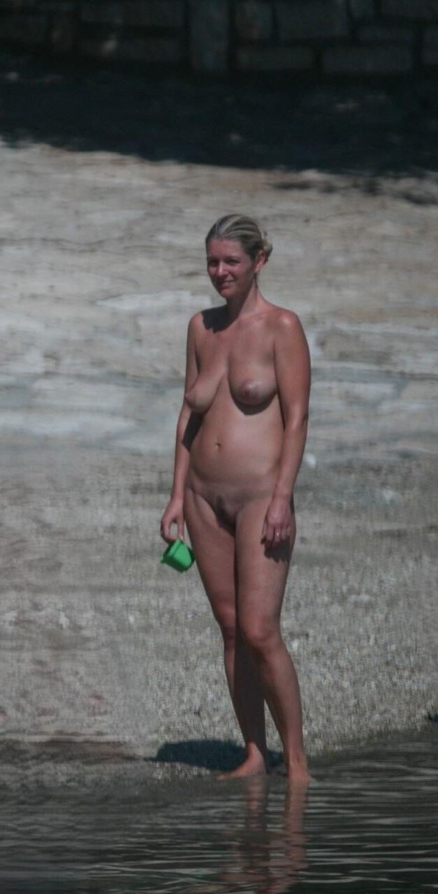 Mamá rubia desnuda caliente en la playa tiene grandes tetas