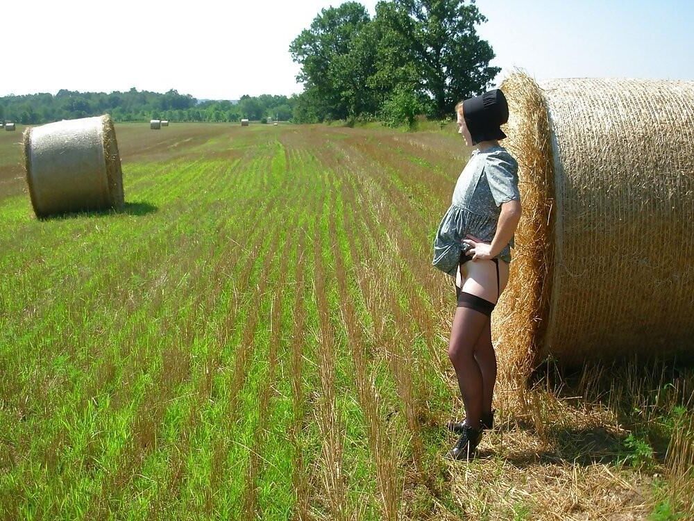 アーミッシュの生姜の女性が屋外で服を脱ぐ