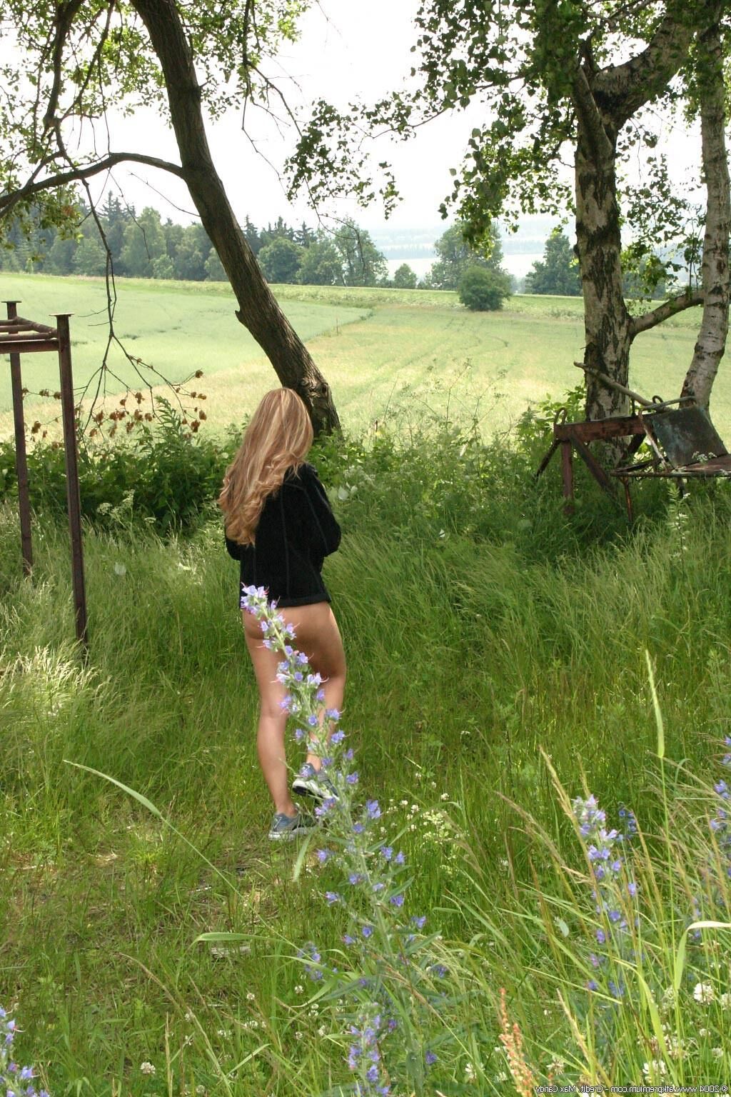 Rubia rusa posando y meando en el campo