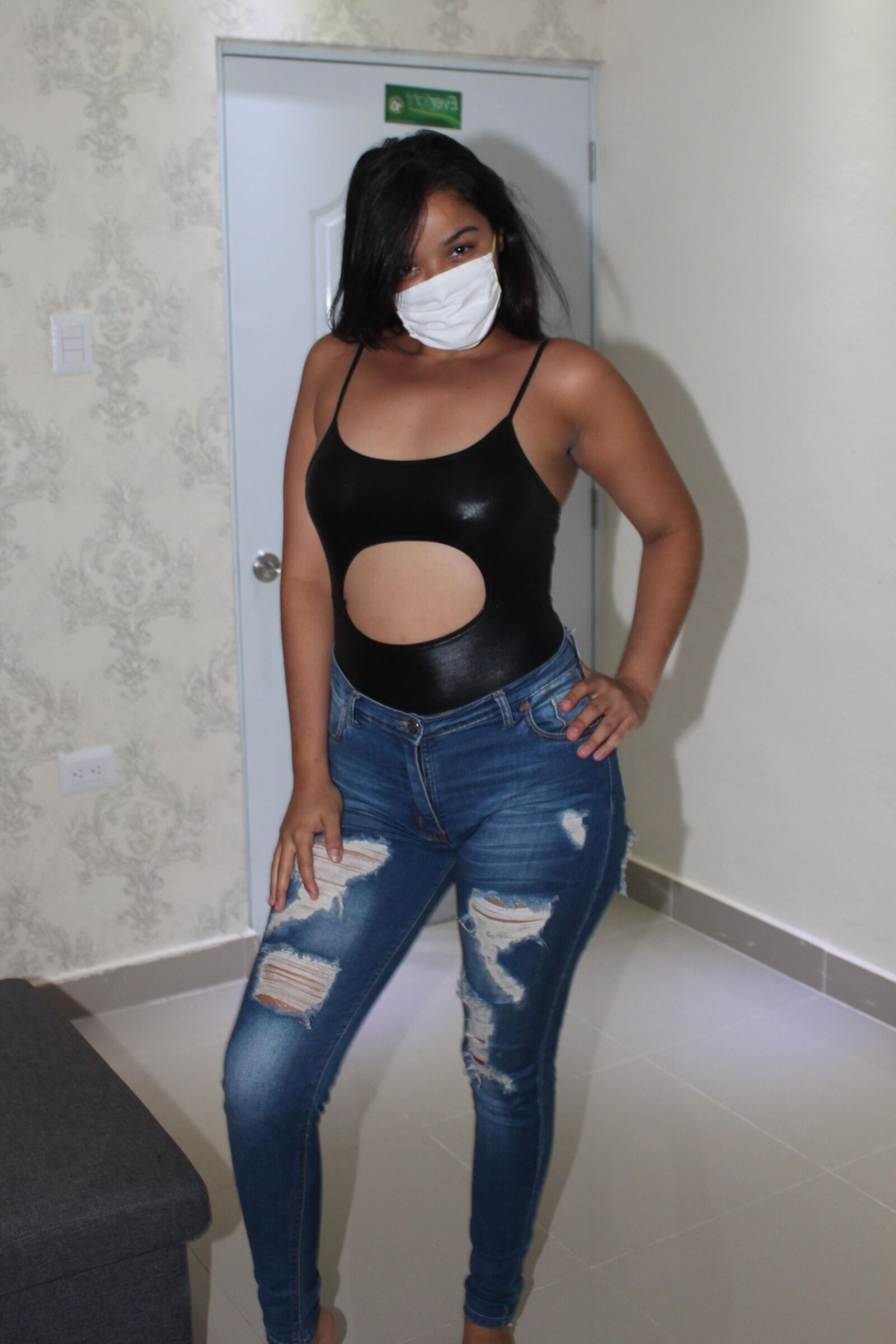 Bonita latina con un sexy top negro y jeans azules muestra sus tetas