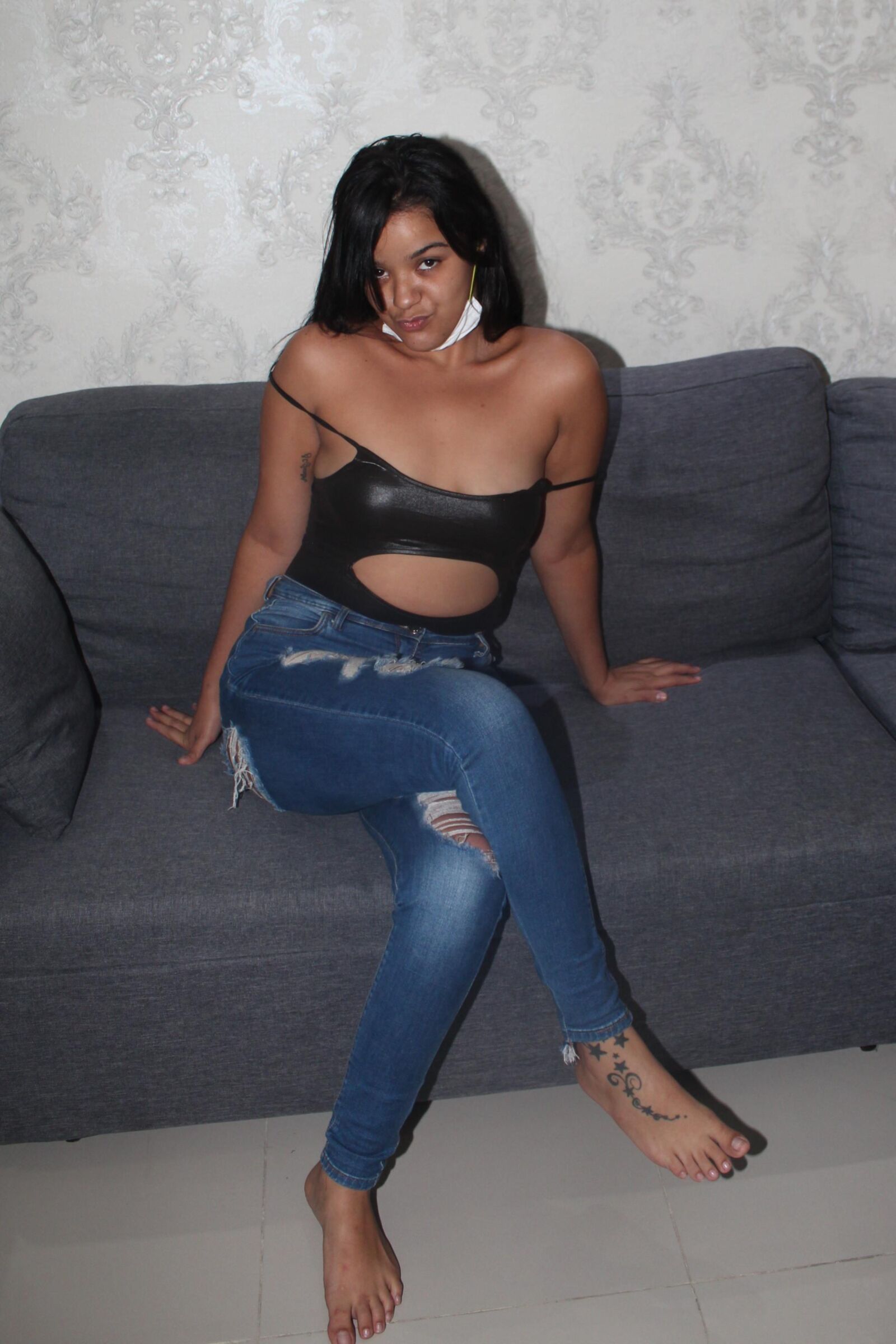 Bonita latina con un sexy top negro y jeans azules muestra sus tetas