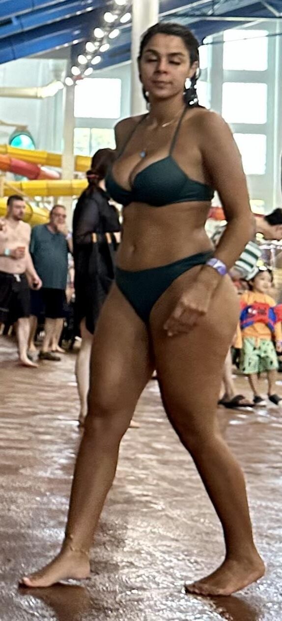 Cabello de cuervo latina en bikini verde tomando daiquiri