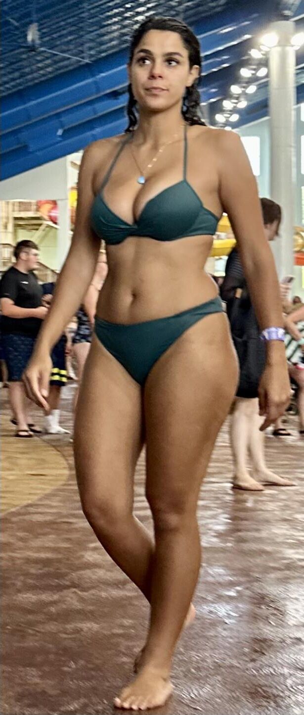 Cabello de cuervo latina en bikini verde tomando daiquiri