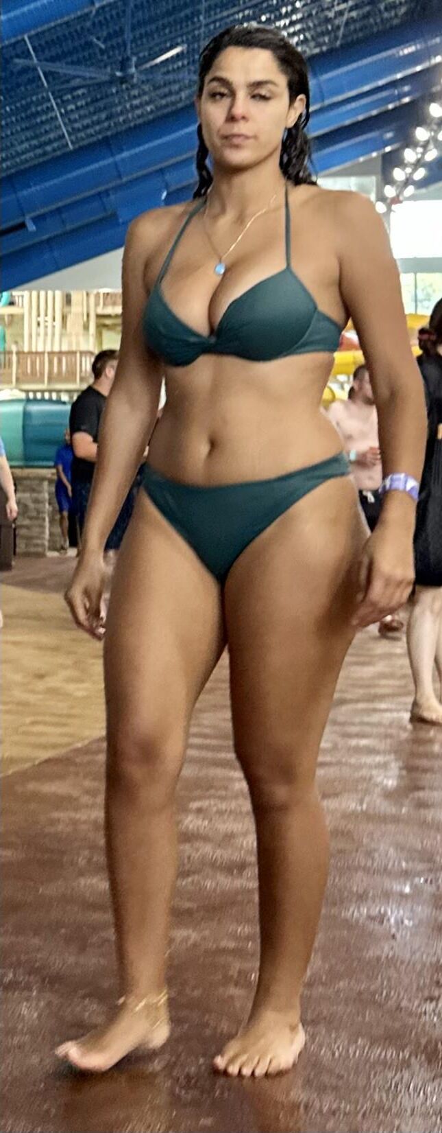 Cabello de cuervo latina en bikini verde tomando daiquiri