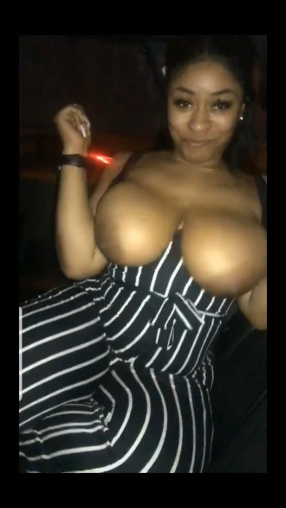 Clignotant ses gros seins noirs dans la voiture