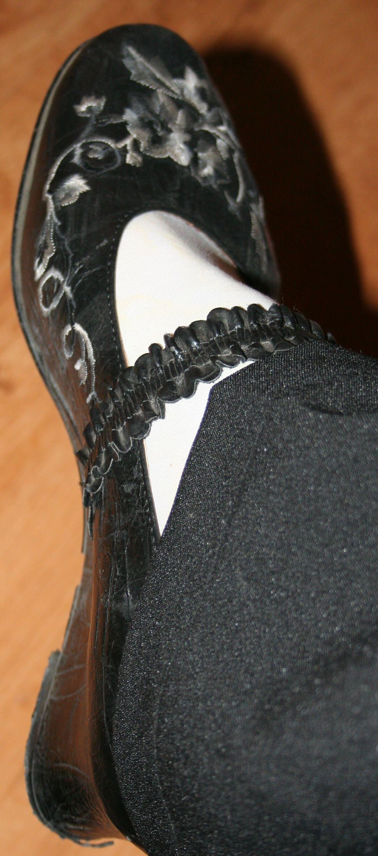 Beine in Strumpfhosen mit Spermaspuren in den Schuhen