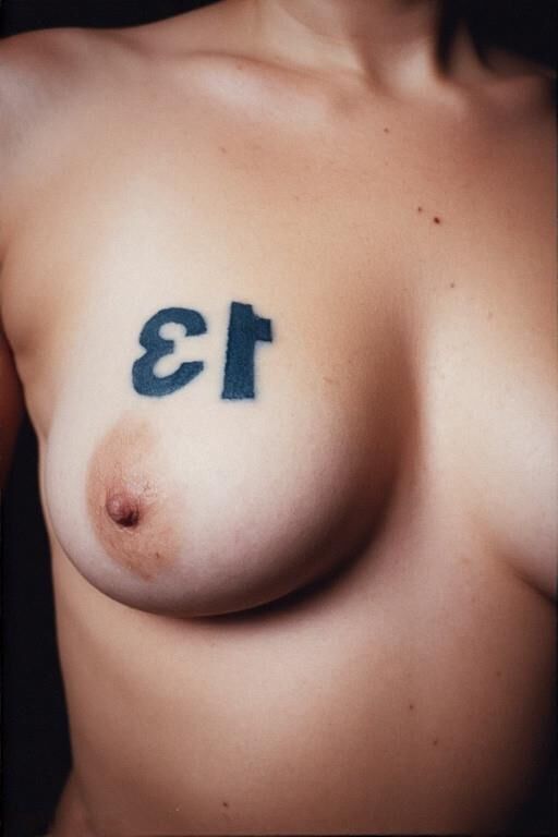Gotta tattooed tit say number 