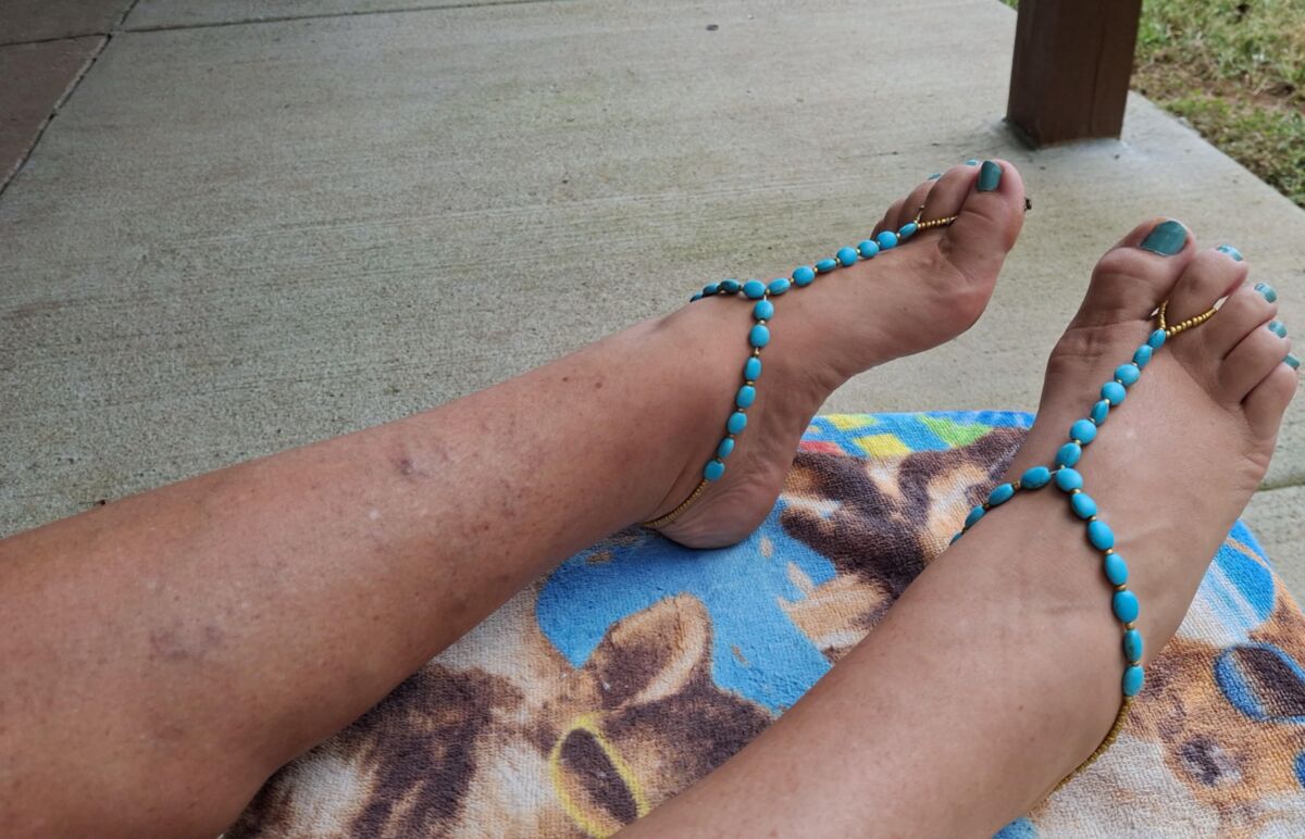 Pés fofos e dedos dos pés pintados em sandálias descalças