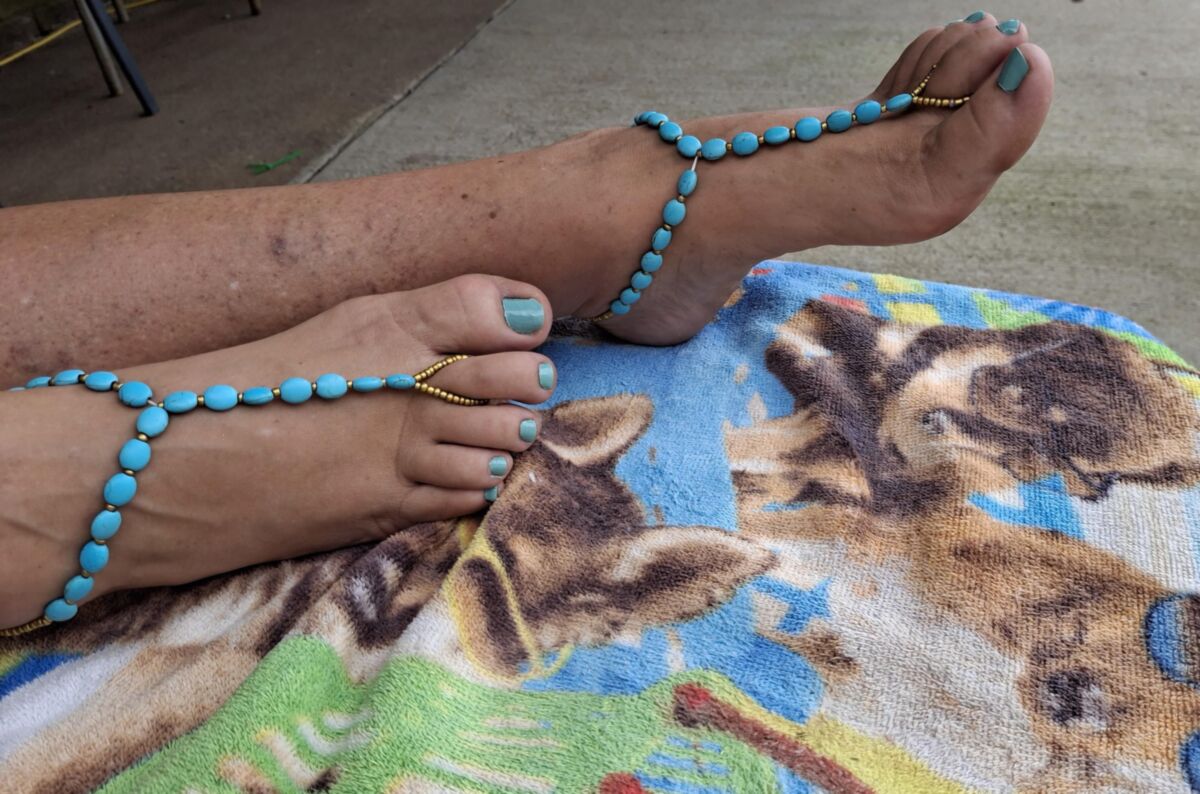 Pés fofos e dedos dos pés pintados em sandálias descalças