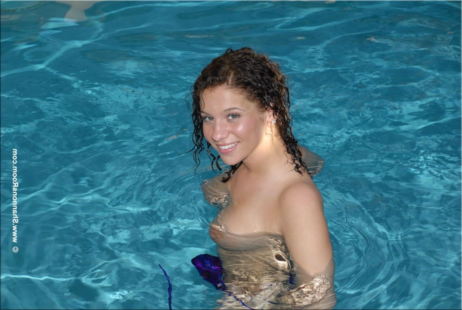 Ellie Busty Babe dans un bikini violet révélateur devient seins nus