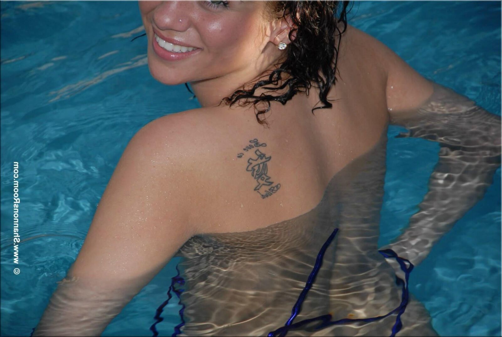 Ellie Busty Babe dans un bikini violet révélateur devient seins nus