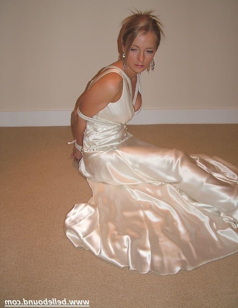 Charlie Dee amarrado em vestido branco de cetim