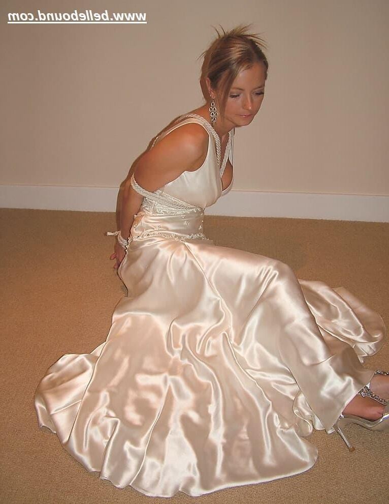 Charlie Dee amarrado em vestido branco de cetim