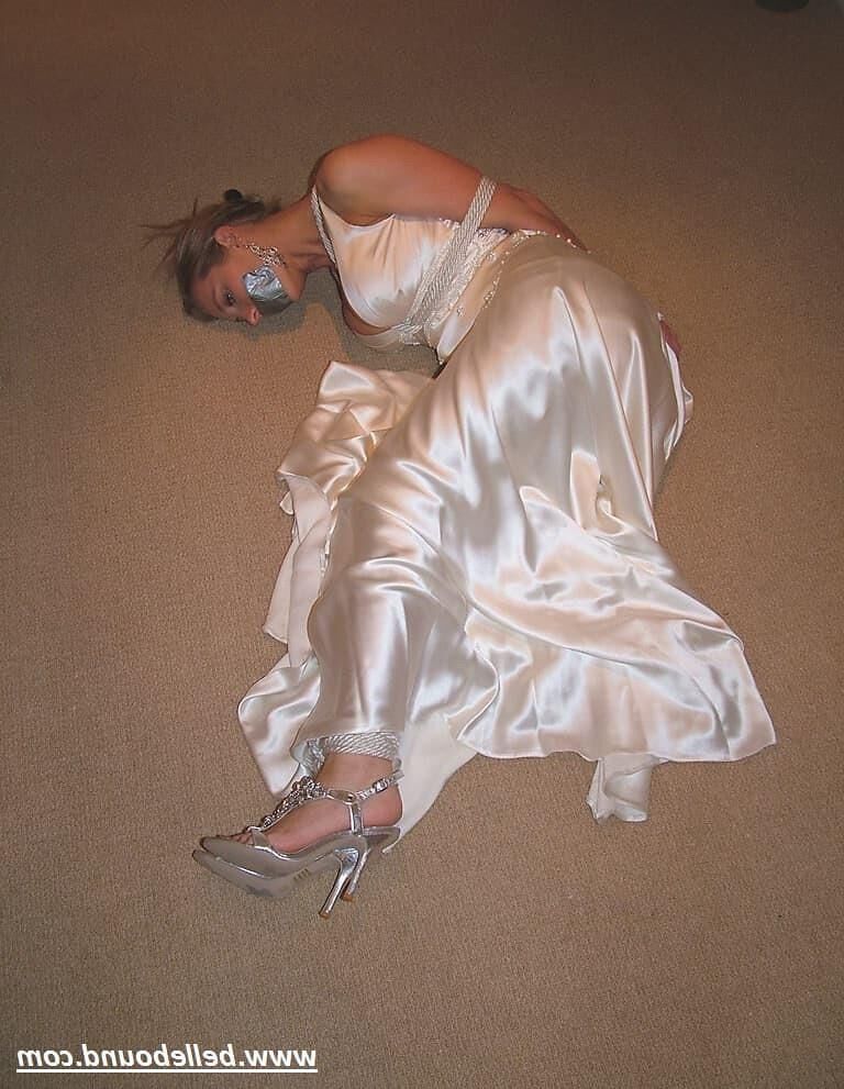 Charlie Dee amarrado em vestido branco de cetim