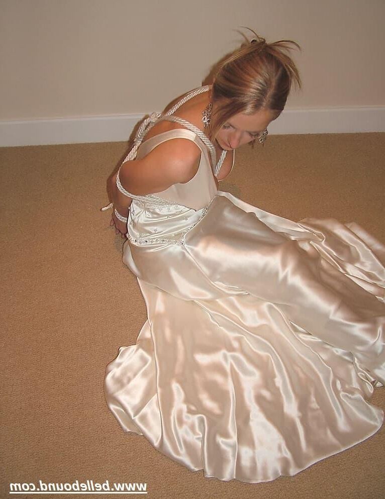 Charlie Dee amarrado em vestido branco de cetim