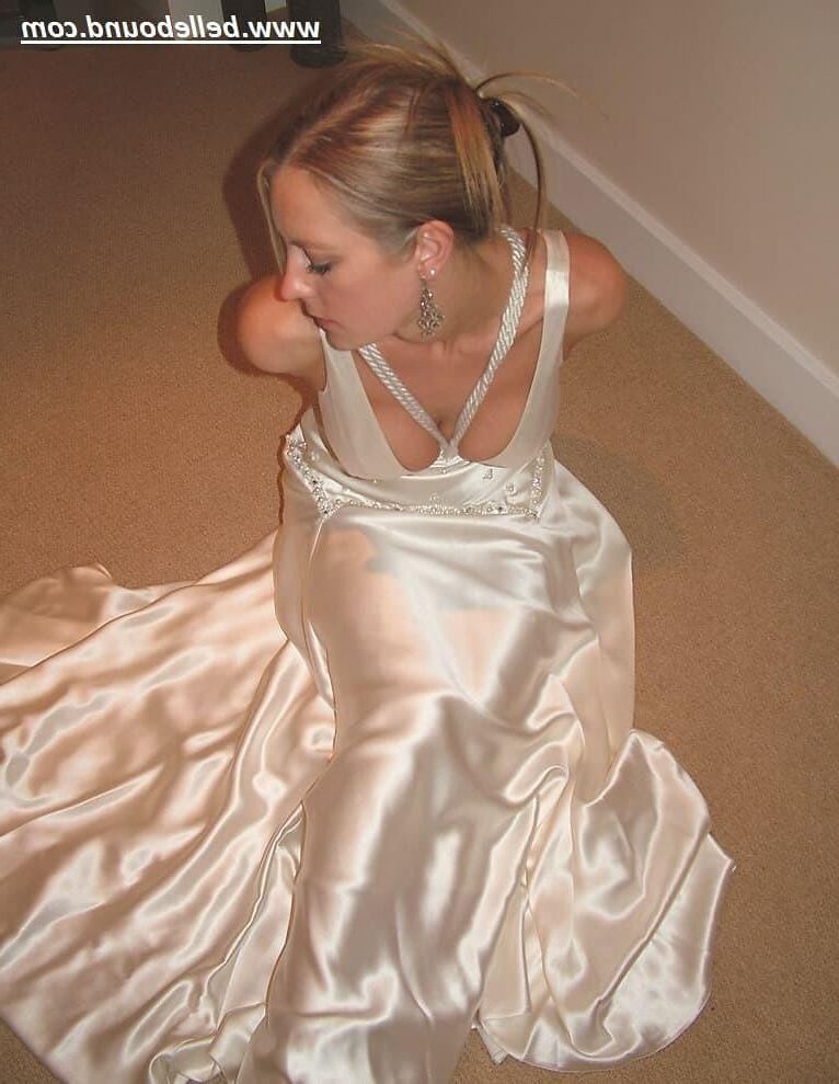 Charlie Dee amarrado em vestido branco de cetim