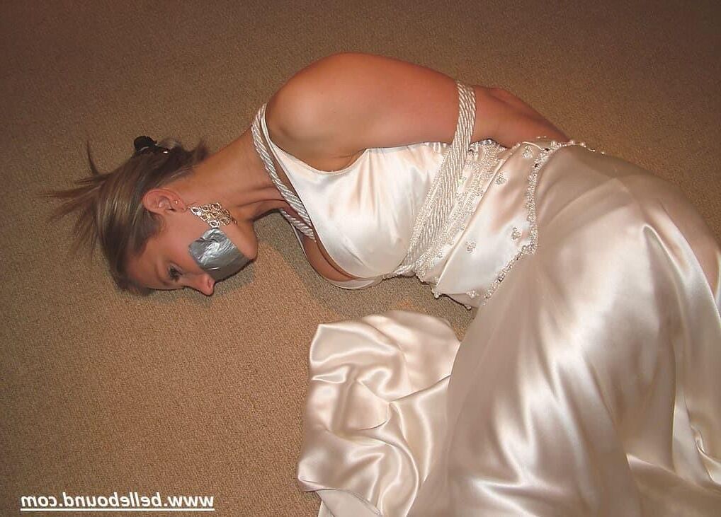Charlie Dee amarrado em vestido branco de cetim