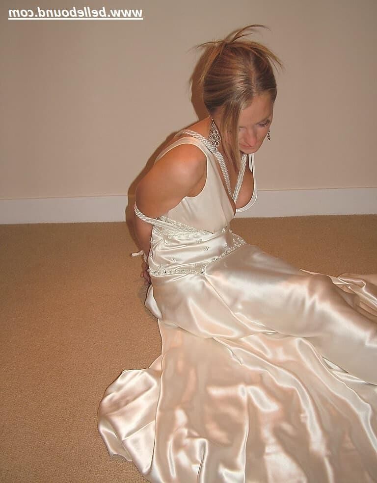 Charlie Dee amarrado em vestido branco de cetim