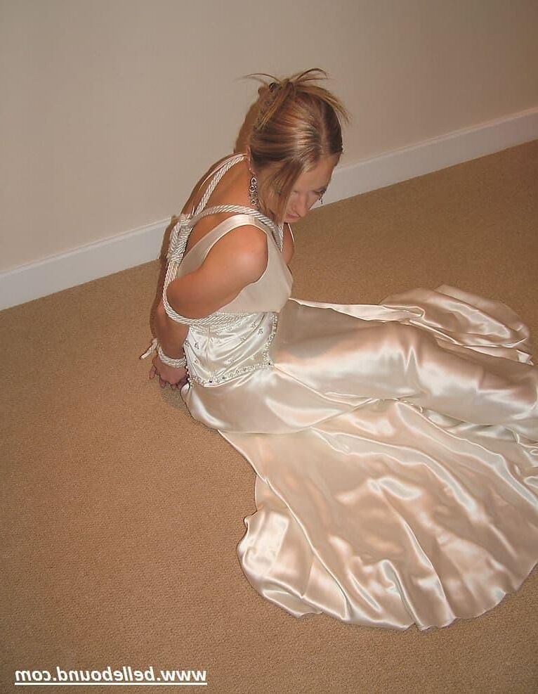 Charlie Dee amarrado em vestido branco de cetim