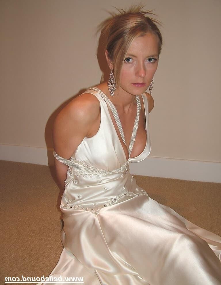 Charlie Dee amarrado em vestido branco de cetim